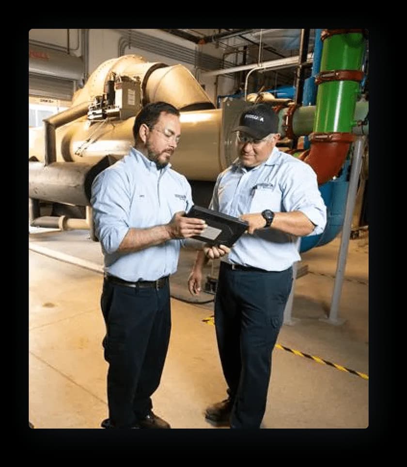 Comfort Systems USA employees reviewing a tablet in a mechanical room, a Workmates customer